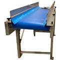 Cinta transportadora apta para uso alimentario con banda azul sanitaria y guías laterales ajustables de acero inoxidable.